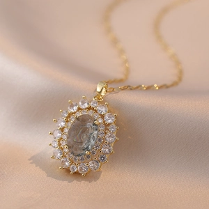 Close-up of vintage gold necklace with green oval gemstone and sunflower diamond setting