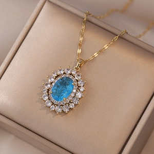 Detail of oval blue gemstone pendant with white zircon halo on champagne gift box