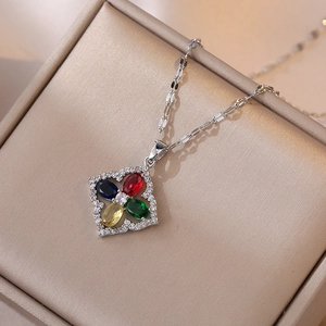 Macro detail of silver four-leaf clover necklace with colorful zircon stones on jewelry box
