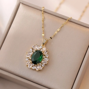 Elegant gold necklace with oval emerald green zircon pendant in a beige jewelry display box