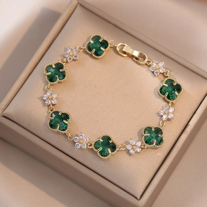 Elegant gold bracelet with five green clover motifs and six white zircon flowers