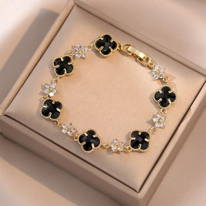 Detailed shot of emerald four-leaf clover bracelet with white zircons in a jewelry box