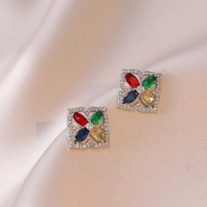 Square vintage stud earrings with colorful zircon stones on champagne satin fabric
