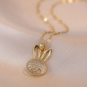 Golden micro-paved zircon rabbit pendant necklace for women on elegant silk background