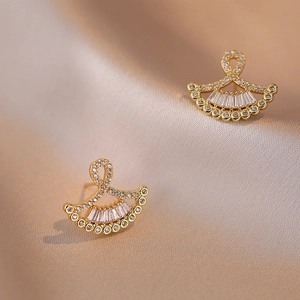 Elegant gold fan-shaped stud earrings with sparkling zircons on a silk background