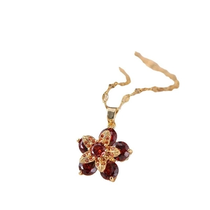 Elegante collana con ciondolo a fiore rotante rosso in acciaio al titanio dorato e zirconi