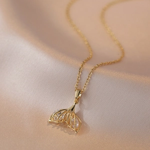 Collier queue de poisson doré poli avec zircons brillants sur fond de soie