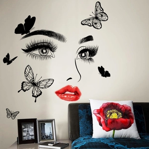 Detail of creative wall sticker featuring female eyes and red lips with flying butterflies