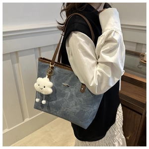 Borsa tote in denim blu con finiture in pelle marrone e ciondolo a forma di nuvola