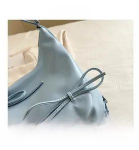 Detail of light blue hobo bag with delicate bow knot and premium stitching craft