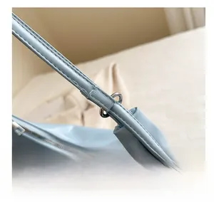 Macro detail of light blue cloud bag showing silver hardware and smooth PU leather strap