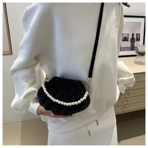Elegant black shell-shaped crossbody bag with pearl handle and quilted velvet texture