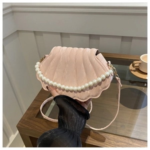Detailed view of pink shell bag with quilted texture and elegant pearl top handle