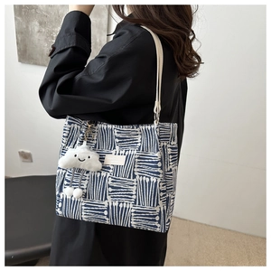 Blue and white geometric canvas tote bag with leather strap and cloud pendant charm