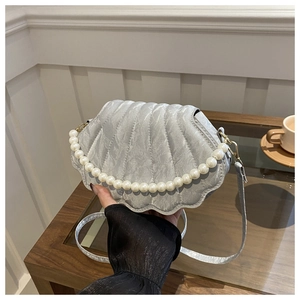 Detailed view of silver shell-shaped bag with pearl handle and quilted texture fabric