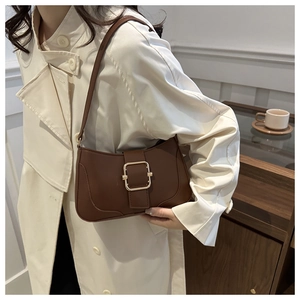 Detailed view of a dark brown retro leather underarm bag with a gold square buckle