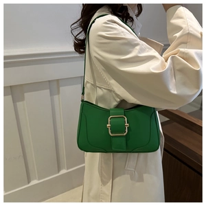 Detail of trendy bright green crescent bag with a large gold square buckle on a model