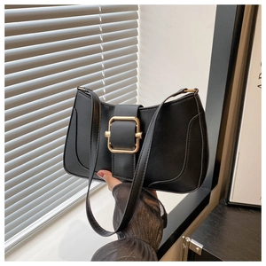 Detail of black faux leather underarm bag with decorative gold square metal buckle