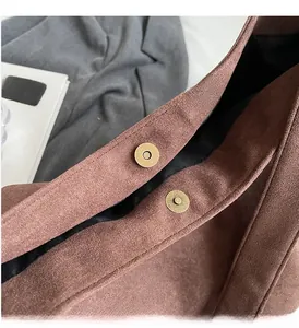 Détail du fermoir magnétique et texture suédée marron d'un grand sac cabas chic