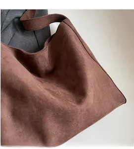 Détail de la texture en daim marron doux et design minimaliste d'un grand sac cabas