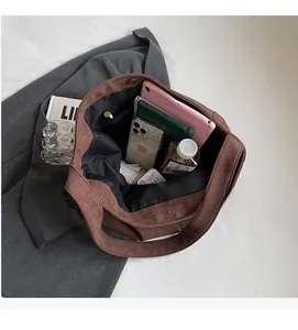 Intérieur spacieux du cabas en daim marron avec tablette et accessoires essentiels