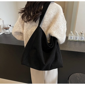 Vue arrière d'un grand sac cabas en toile noire porté par un mannequin chic