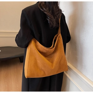 Détail du grand sac hobo en daim moutarde montrant sa texture douce et sa large bandoulière