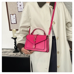 Détail d'un sac à bandoulière rose chic avec boucle dorée et texture cuir raffinée
