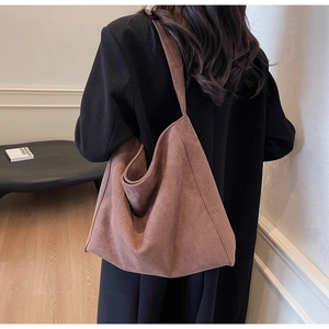 Grand sac cabas marron en daim sur modèle montrant la forme souple et la texture drapée