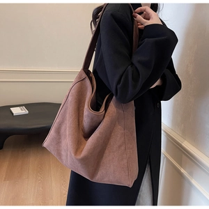 Détail du grand sac cabas en daim marron avec une grande capacité et une large bandoulière