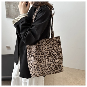 Dettaglio della borsa tote scamosciata leopardata con tasca esterna e cuciture dritte