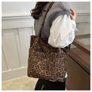 Dettaglio della grande borsa tote in pelle scamosciata leopardata con tasche frontali
