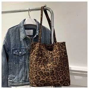Dettaglio della borsa tote leopardata con doppie tasche frontali e morbida texture scamosciata