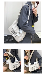 Detail of white canvas tote bag with fashion letter print and cloud plush pendant charm
