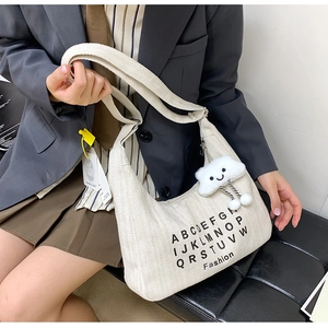 Minimalist beige canvas tote bag with letter print and plush cloud charm crossbody