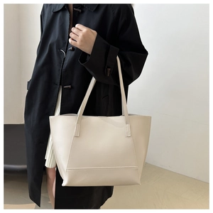 Détail du grand sac cabas minimaliste en cuir crème avec surpiqûres et longues bandoulières