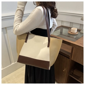 Détail d'un grand sac cabas bicolore en similicuir beige et marron pour le quotidien