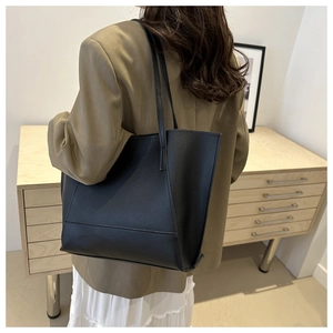 Détails du sac fourre-tout en cuir noir avec des surpiqûres minimalistes et modernes