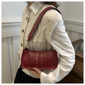 Détail du sac à bandoulière en similicuir bordeaux avec rivets argentés et style rétro