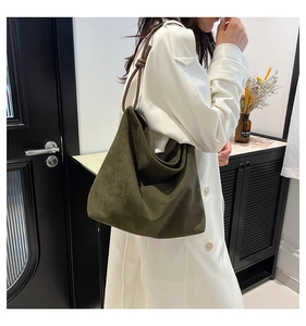 Detail of forest green suede tote bag with knotted slim leather shoulder straps