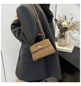Détail d'un sac bandoulière vintage en velours marron avec fermoir en métal et sangle