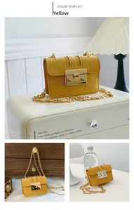 Detail of yellow mini crossbody bag featuring suede texture and gold chain strap