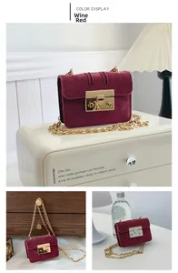 Close-up of burgundy suede flap bag with gold chain strap and rectangular metal lock
