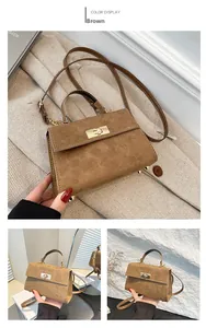 Détails du sac en daim marron avec fermoir doré et pieds de protection métalliques