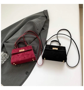 Détails de sacs à main en velours bordeaux et noir avec fermoir doré et pieds en métal