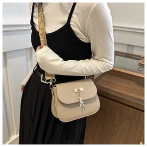 Beige crossbody square bag with gold deer charm and wide jacquard strap on model