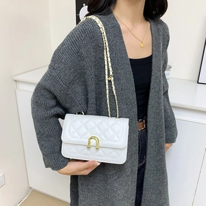 Elegante borsa trapuntata bianca con dettagli dorati e tracolla a catena su modella