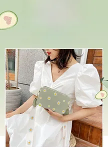 Detail of avocado green daisy crossbody bag with floral wide canvas shoulder strap