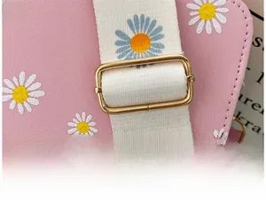 Detail of adjustable golden metal buckle on floral daisy pattern wide shoulder strap