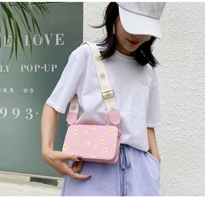 Detail of pink floral crossbody bag with adjustable wide daisy print canvas strap